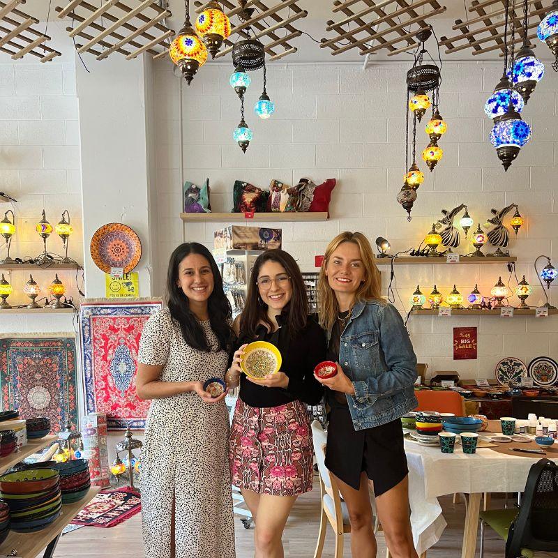 Kettle spout pouring boiling water into coffee grounds in pour-over mug.